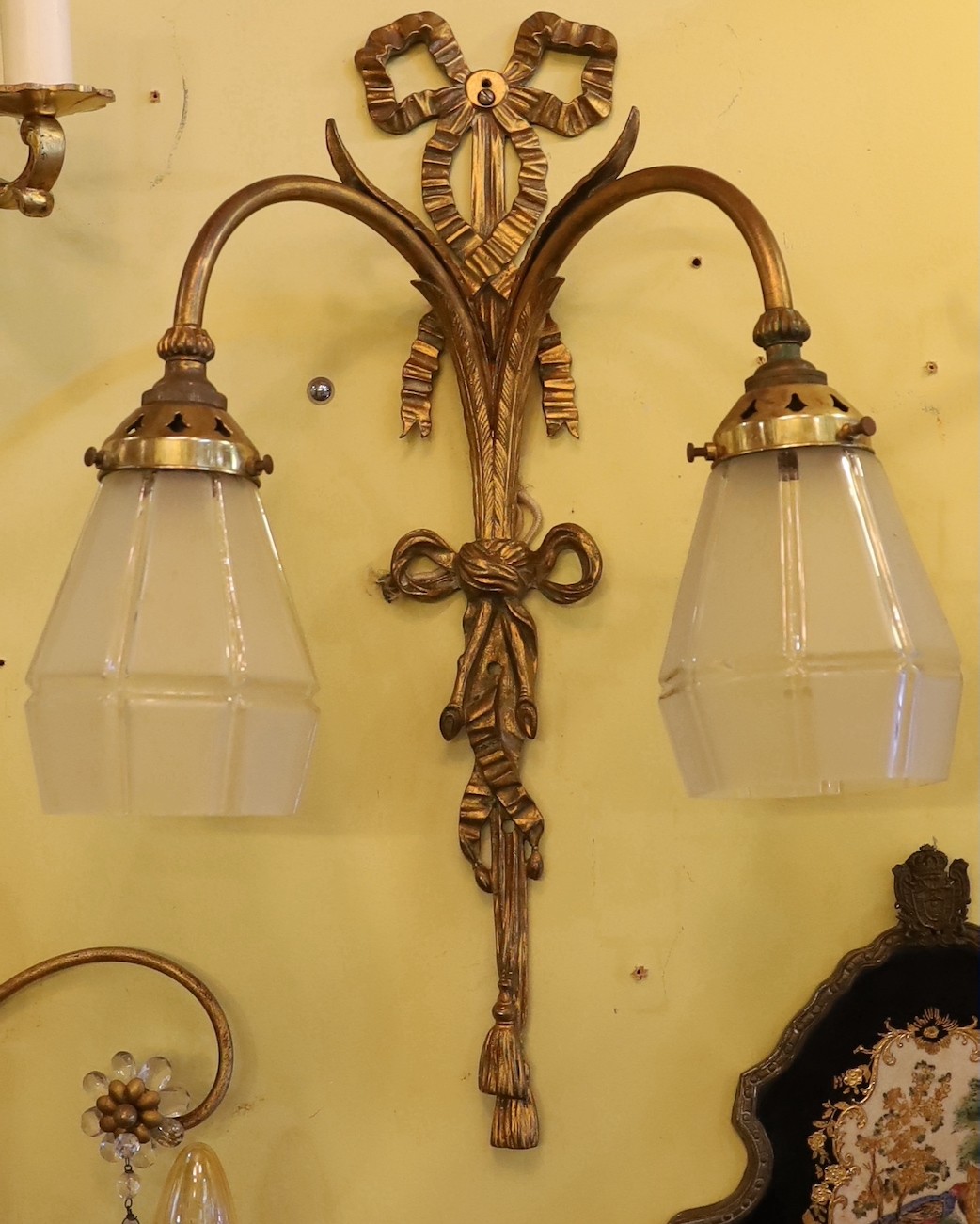 A set of three early 20th century English gilt metal twin branch wall lights with frosted glass shades, height 51cm. width 36cm